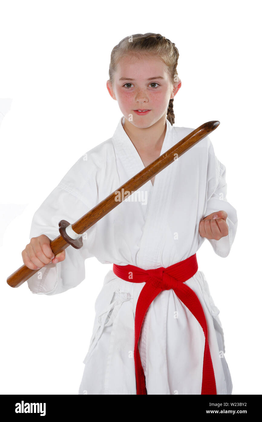 Preteen caucasian girl wearing a karate uniform performing a sword