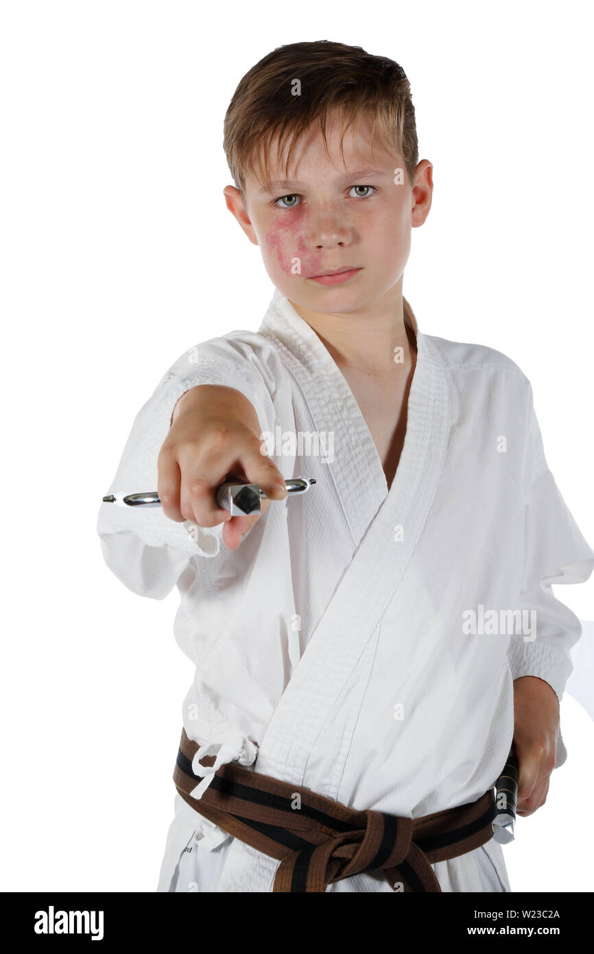 Teenage caucasian boy wearing a karate uniform performing kata with Sai