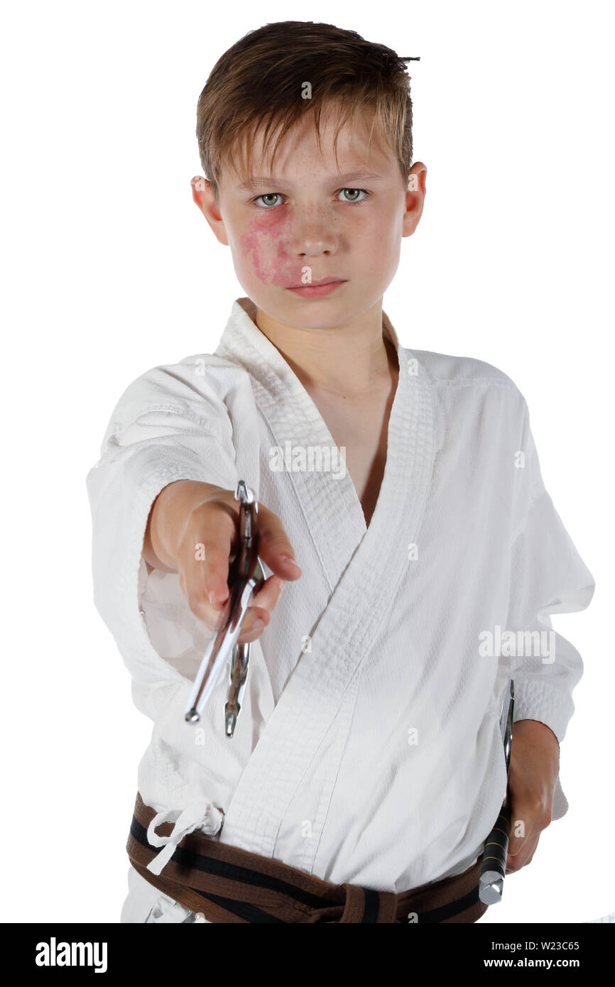 Teenage caucasian boy wearing a karate uniform performing kata with Sai