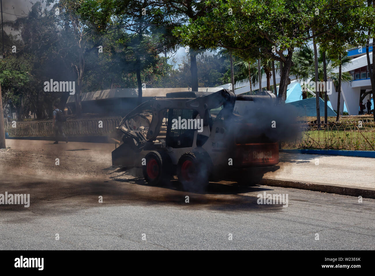 Havana, Cuba - May 29, 2019: Heavy equipment construction machine working in the streets of Havana City, Capital of Cuba, emitting black smoke into th Stock Photo