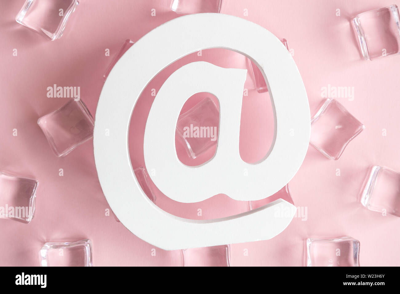 Flat lay of email sign and ice cubes against pastel pink background
