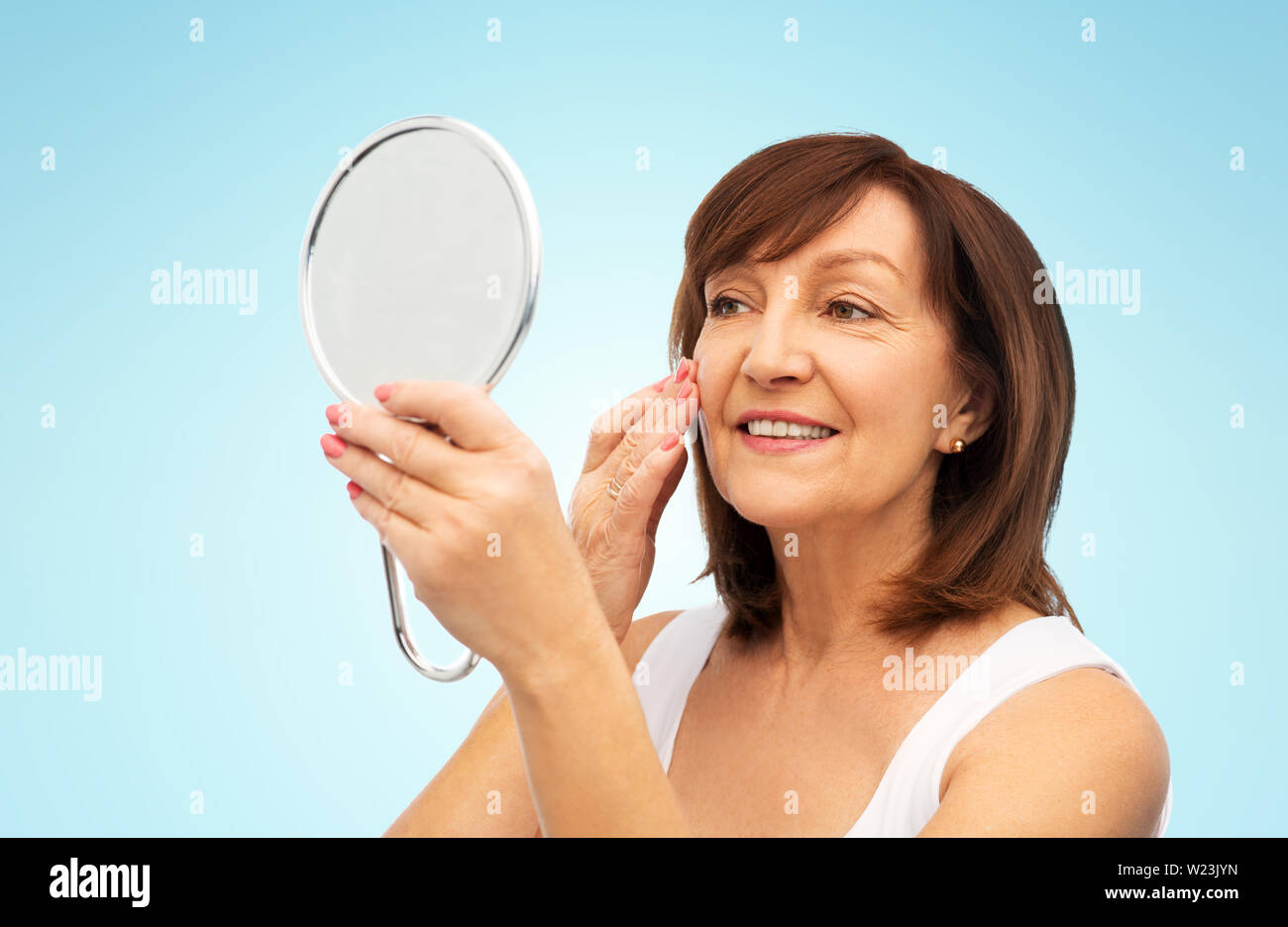 Woman mirror happy touching face hi-res stock photography and images ...