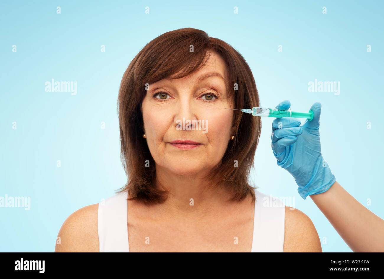 senior woman and cosmetologist's hand with syringe Stock Photo