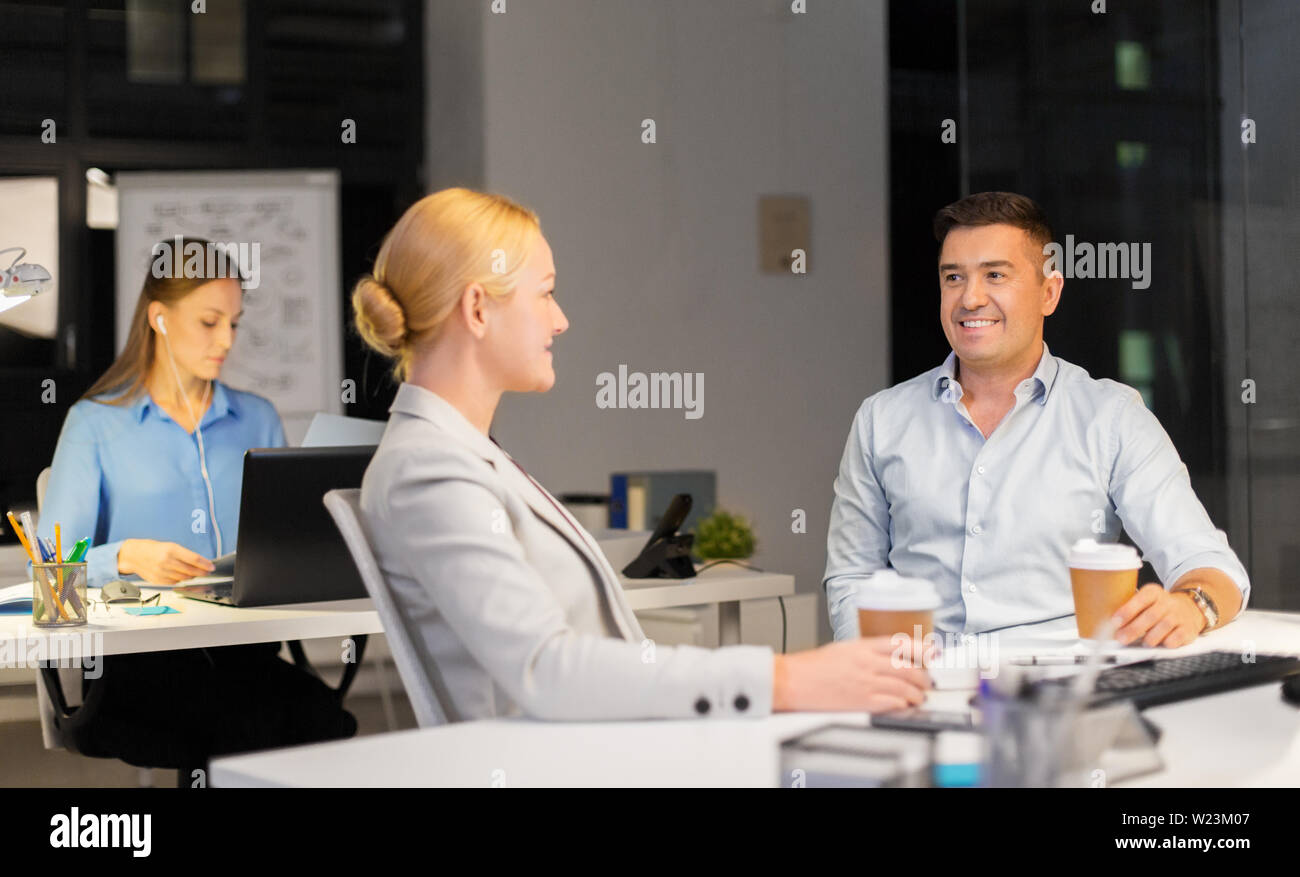 business people drinking coffee at night office Stock Photo Alamy