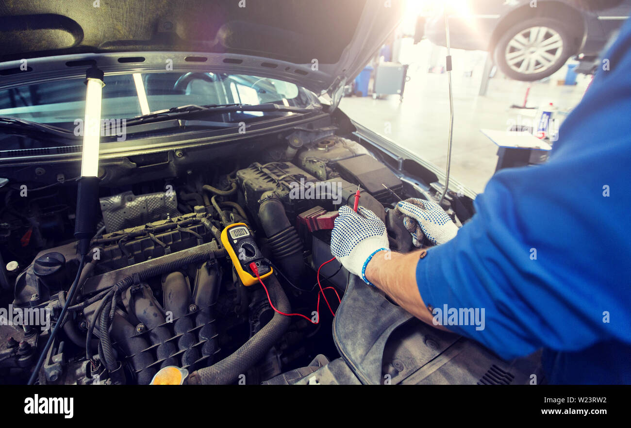 auto mechanic man with multimeter testing battery Stock Photo Alamy