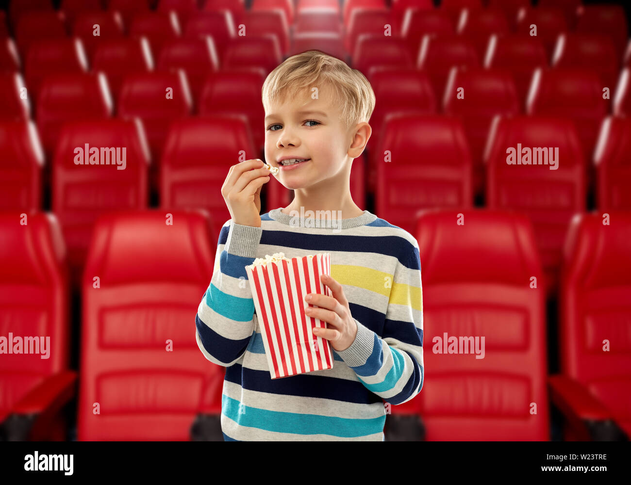 smiling boy eating popcorn at movie theater Stock Photo Alamy