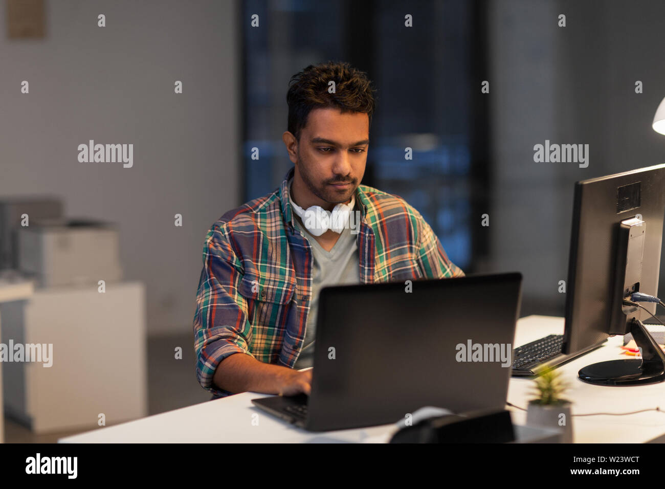 creative man with laptop working at night office Stock Photo - Alamy