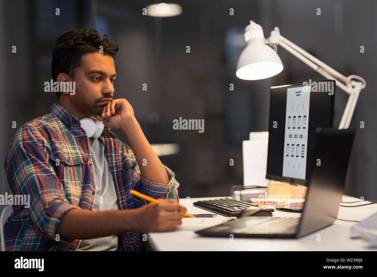 creative man with laptop working at night office Stock Photo