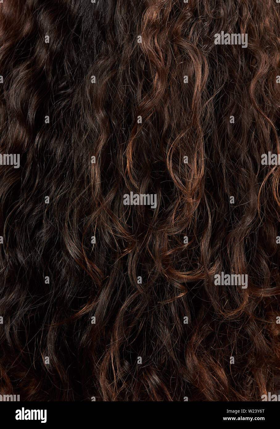 Brown natural woman  curly hair background. Wavy hairstyle Stock Photo