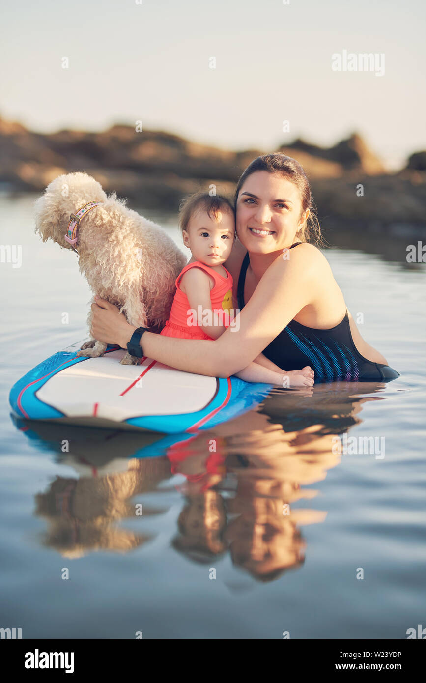 Young Mother With Baby Girl On Surf Board In Sunset Light Stock Photo Alamy