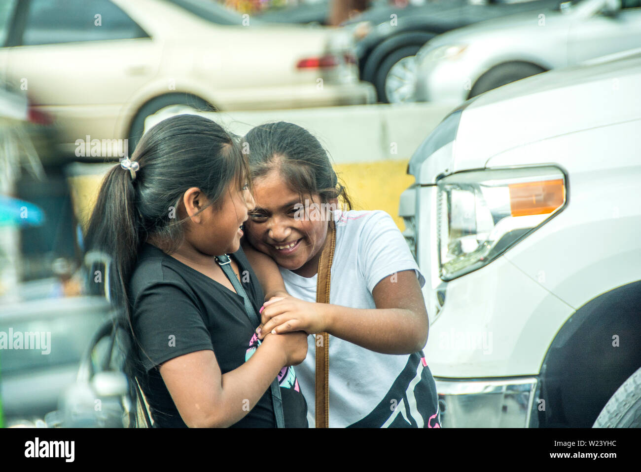 Two young, preteen Mexican girls playing, at the San Ysidro, California and Tijuana, Mexio border crossing; United States and Mexico. Stock Photo