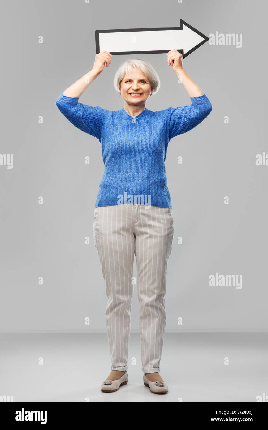 smiling senior woman with big rightwards arrow Stock Photo - Alamy
