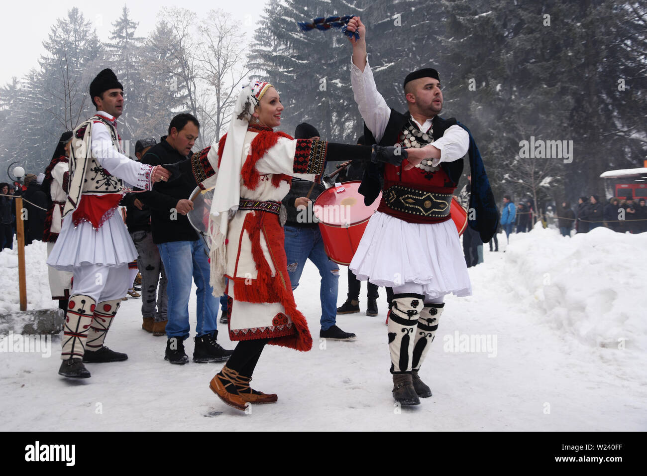 Razlog, Bulgaria - January 12, 2019: People in Bulgarian folk costumes dancing on the snowy streets of Razlog during Starchevata folk festival Stock Photo