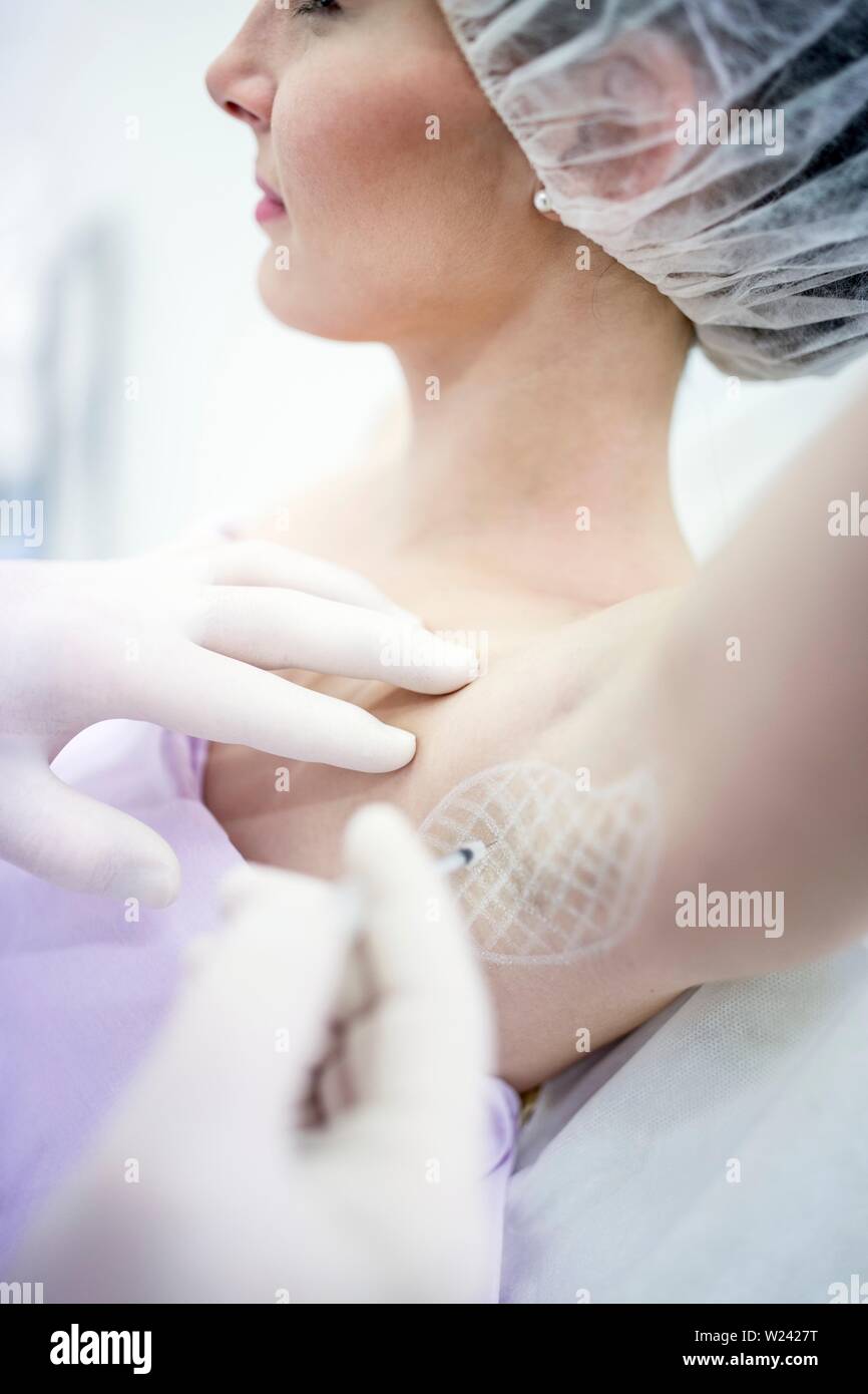 Dermatologist injecting botox in underarm to treat excessive sweating, close-up. Stock Photo