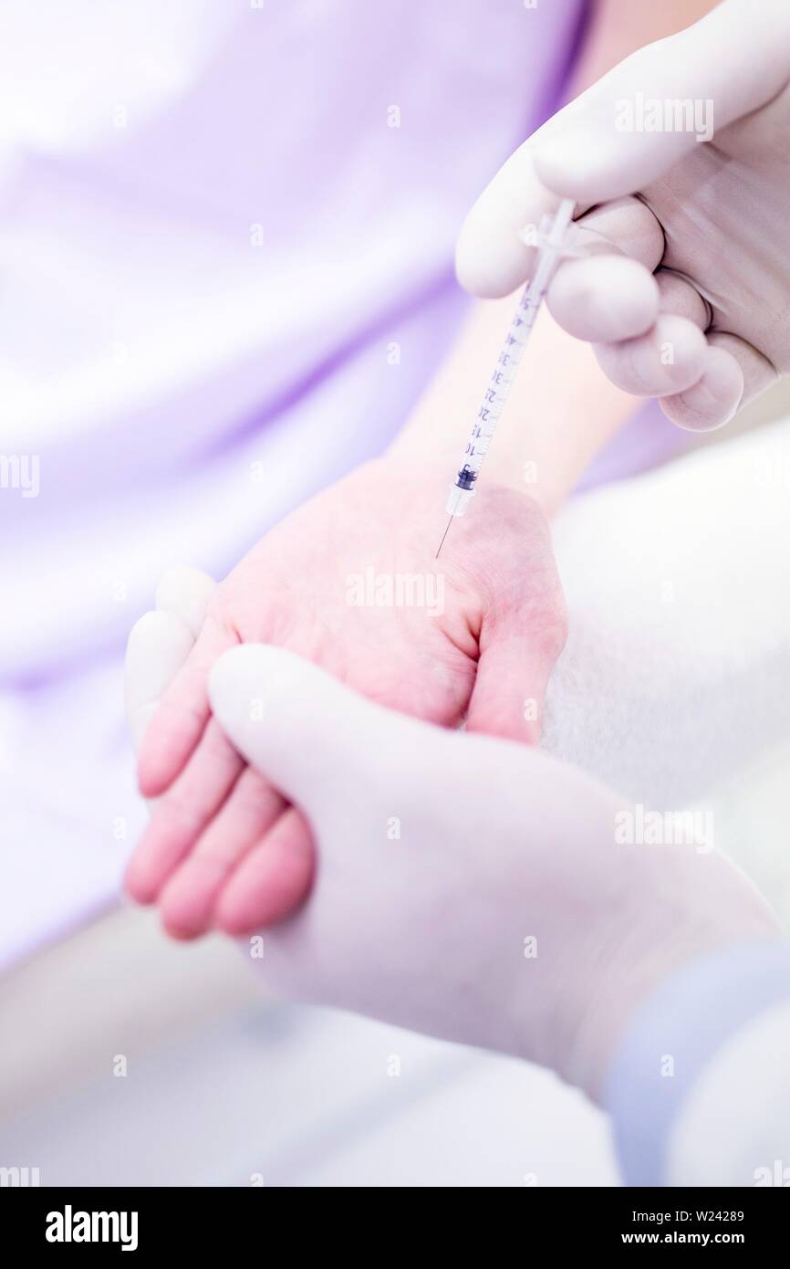 Dermatologist injecting botox on palm to treat excessive sweating, close-up. Stock Photo