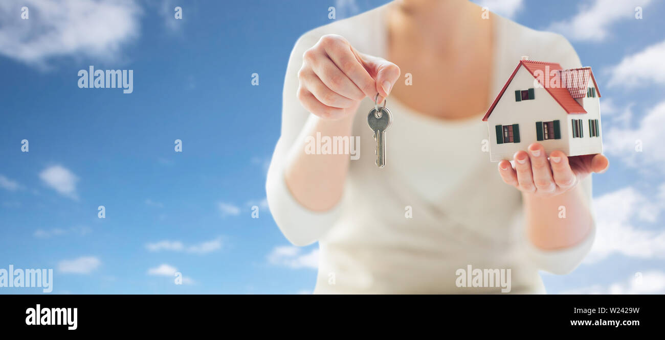 close up of hands holding house model and keys Stock Photo - Alamy