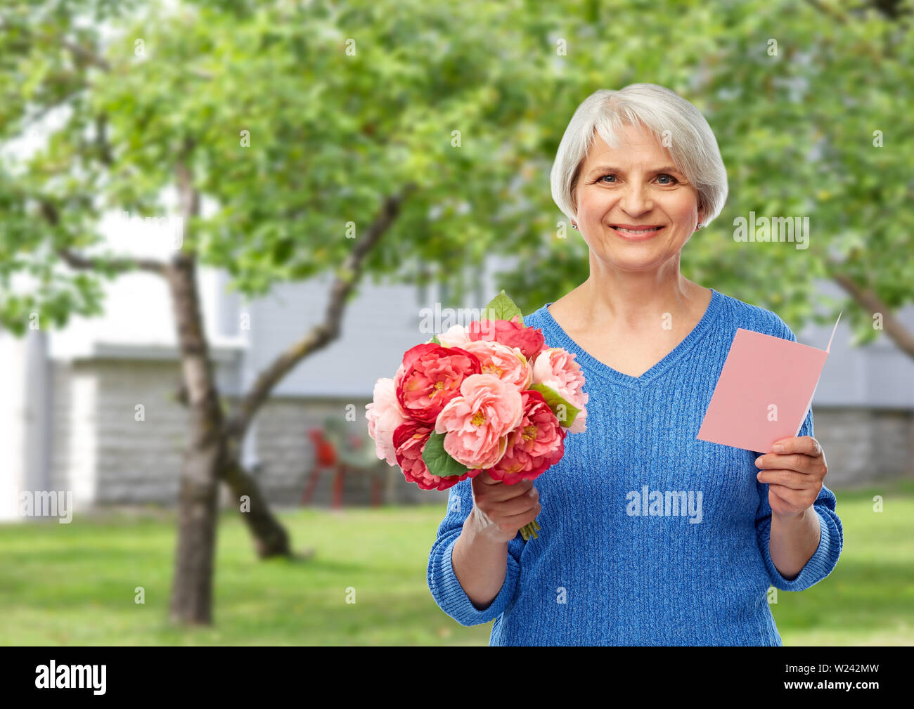 happy senior woman with flowers and greeting card Stock Photo