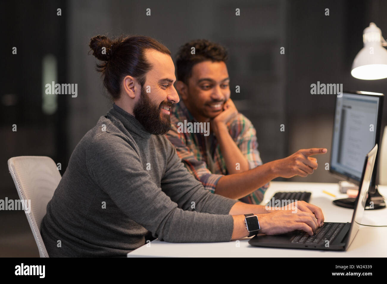 creative team with computer working late at office Stock Photo