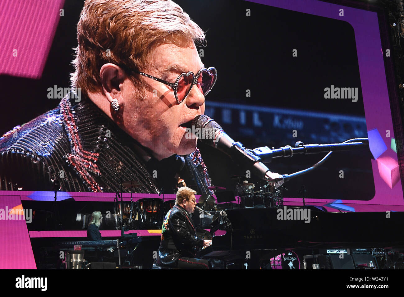 Munich, Germany. 05th July, 2019. The British singer, composer and pianist,  Sir Elton John, sits on a grand piano on stage in the sold-out Olympic Hall  at his additional concert of his