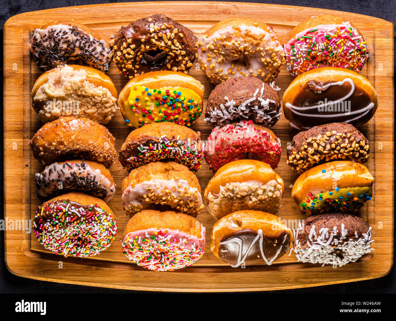 assorted donuts on wooden cutting board Stock Photo