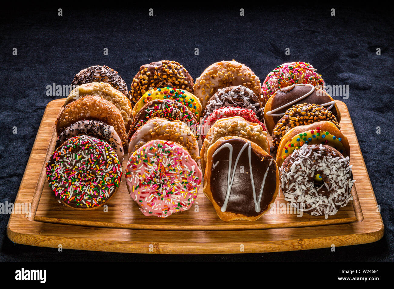 assorted donuts on wooden cutting board Stock Photo