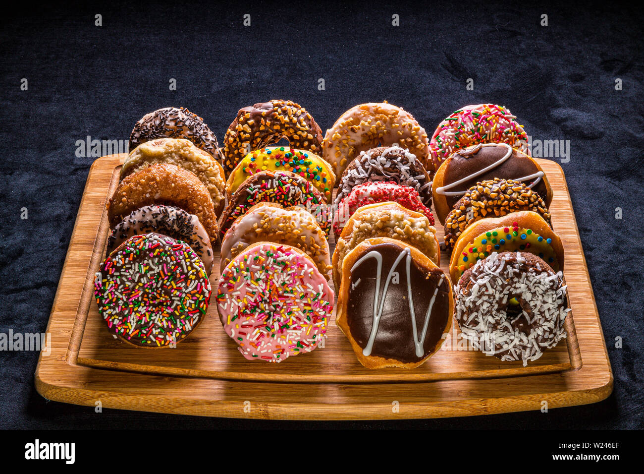 assorted donuts on wooden cutting board Stock Photo