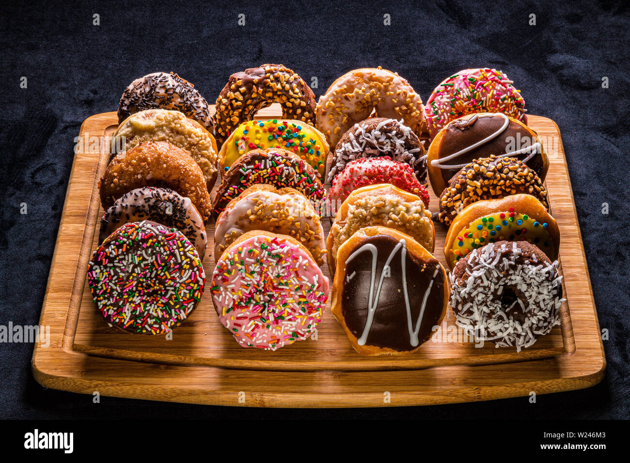 assorted donuts on wooden cutting board Stock Photo