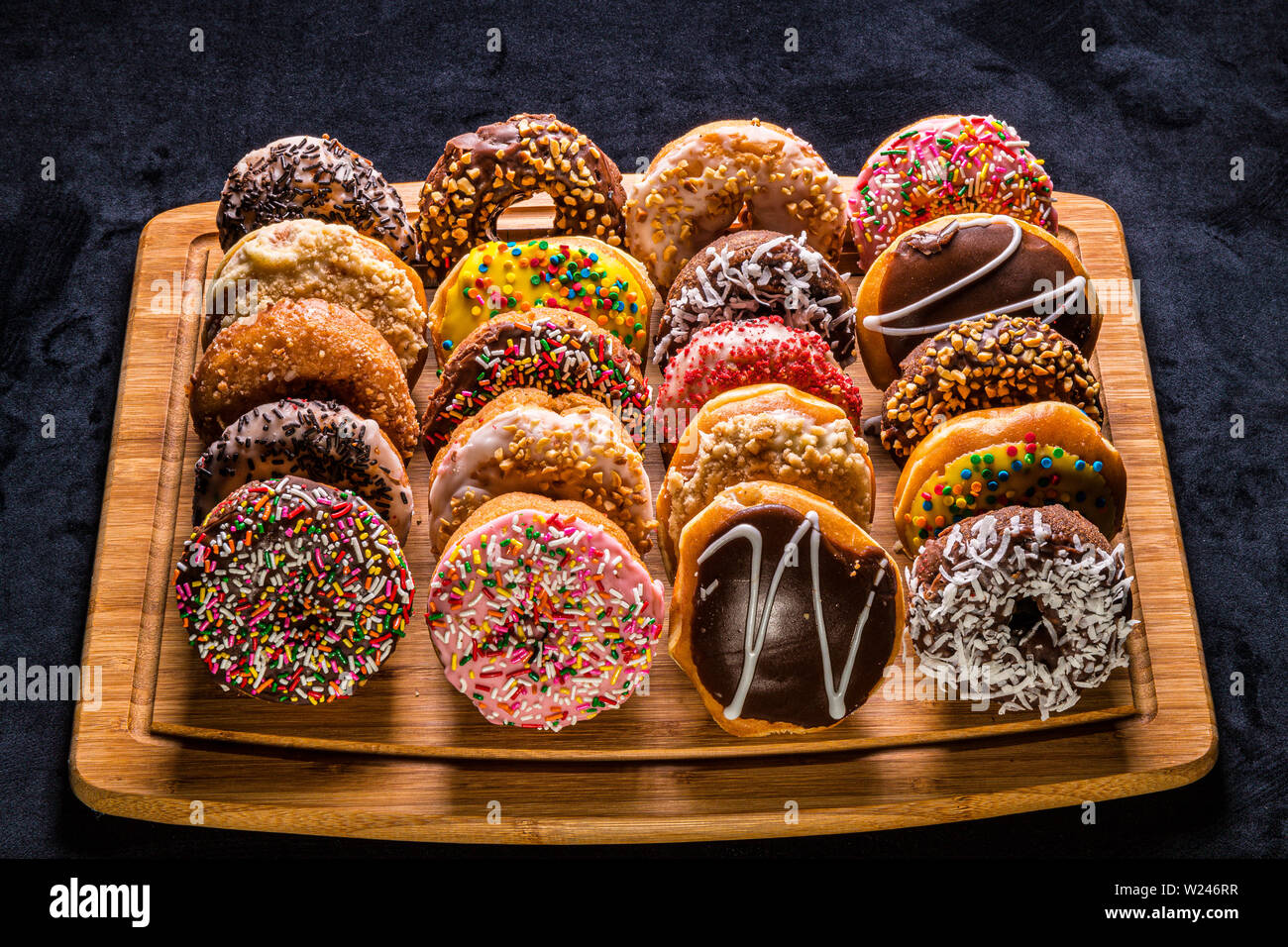 assorted donuts on wooden cutting board Stock Photo