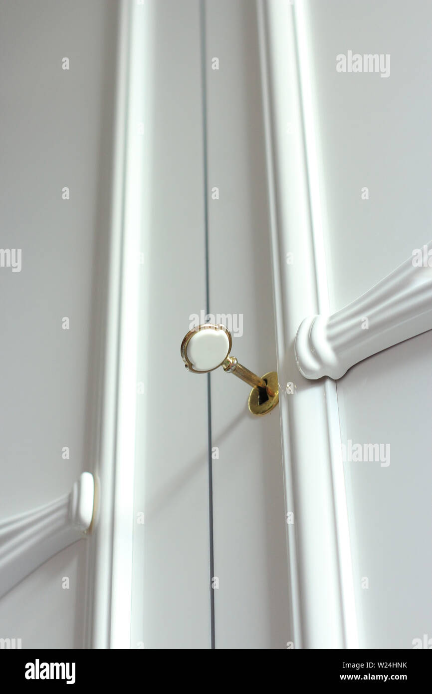 Closeup of white glossy wardrobe with gold key Stock Photo Alamy