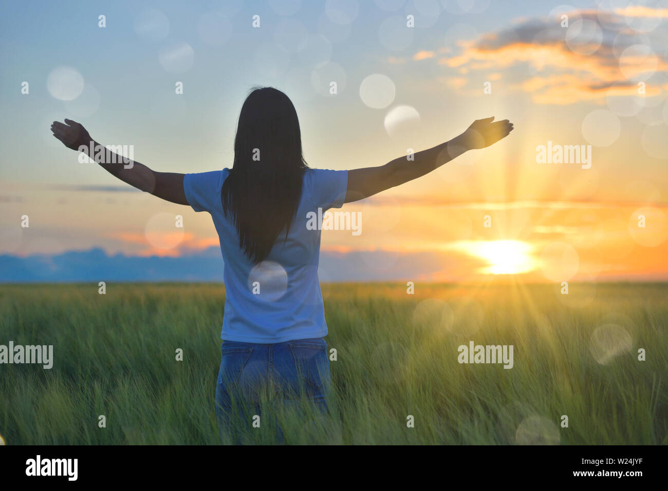 Woman feeling free in a beautiful natural setting, in what field at sunset Stock Photo
