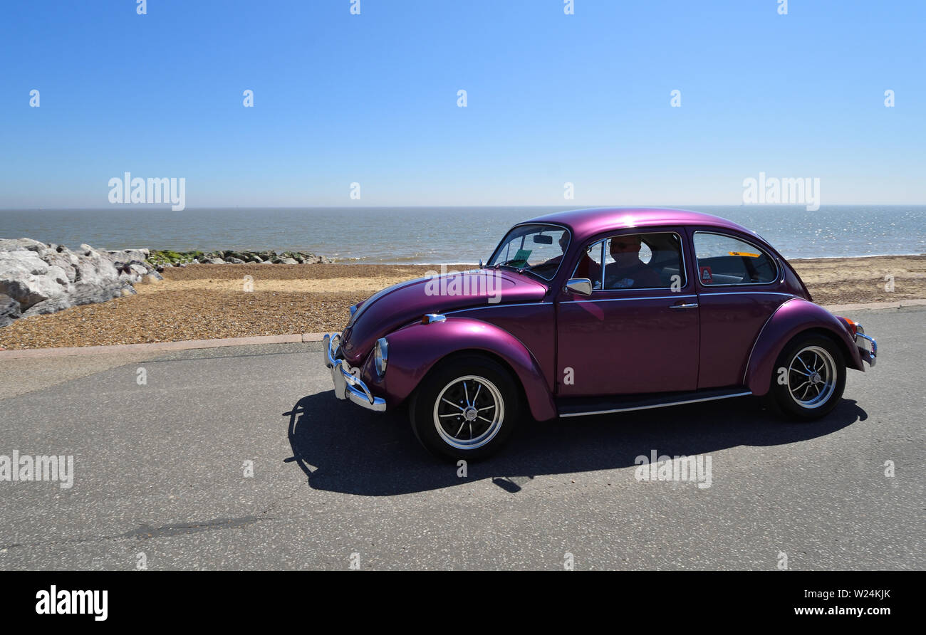 Classic Purple  VW Beetle Motor Car being driven along Seafront  Promenade. Stock Photo