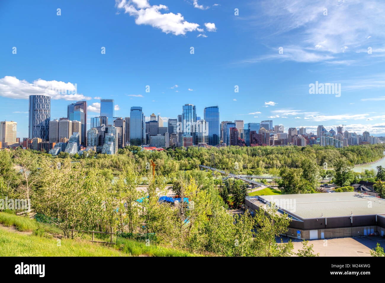 Wide angle view of Calgary downtown urban skyline in Summer with Bow River surrounding the financial district and its skyscrapers. Stock Photo