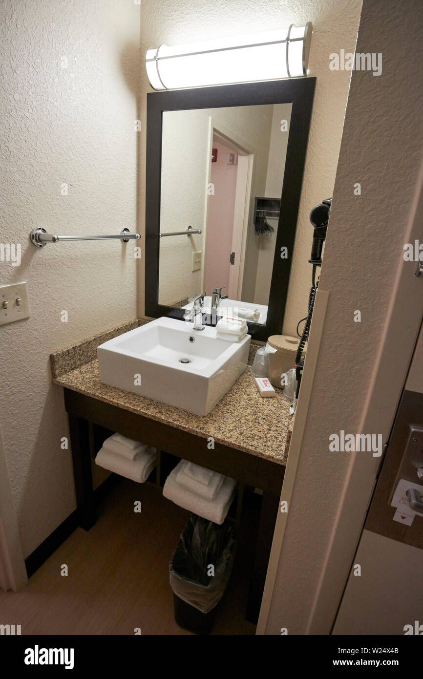 small sink and mirror in small bathroom in a cheap hotel room usa Stock Photo