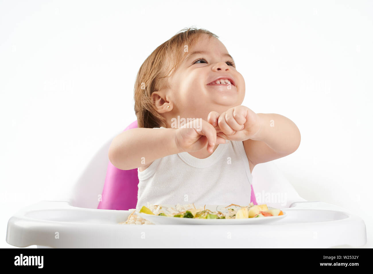 Portrait of baby playing with food isolated on white background Stock Photo