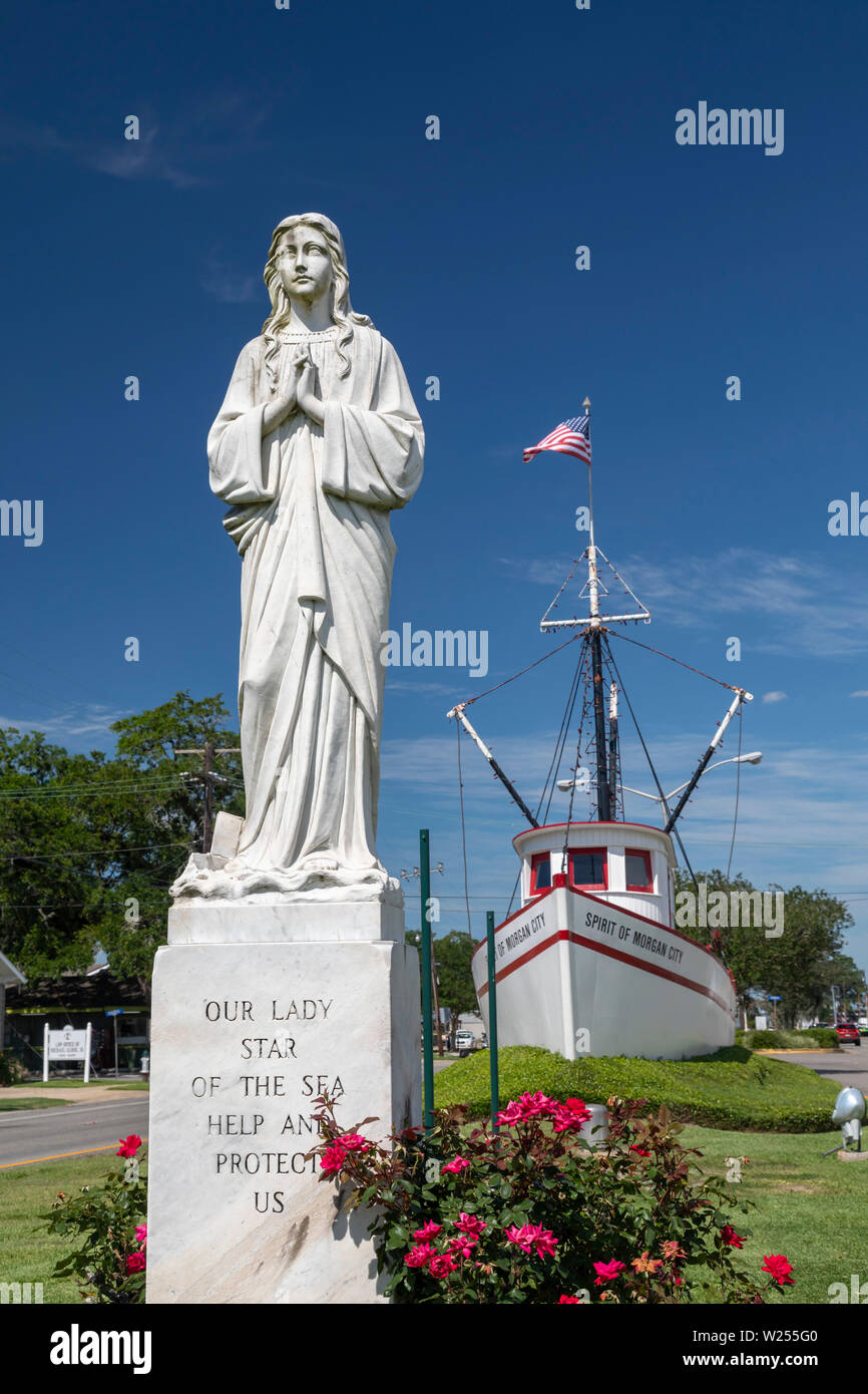 Morgan City, Louisiana - Our Lady Star of the Sea statue in front of the Spirit of Morgan City shrimp trawler on the town's main street. Shrimping is Stock Photo