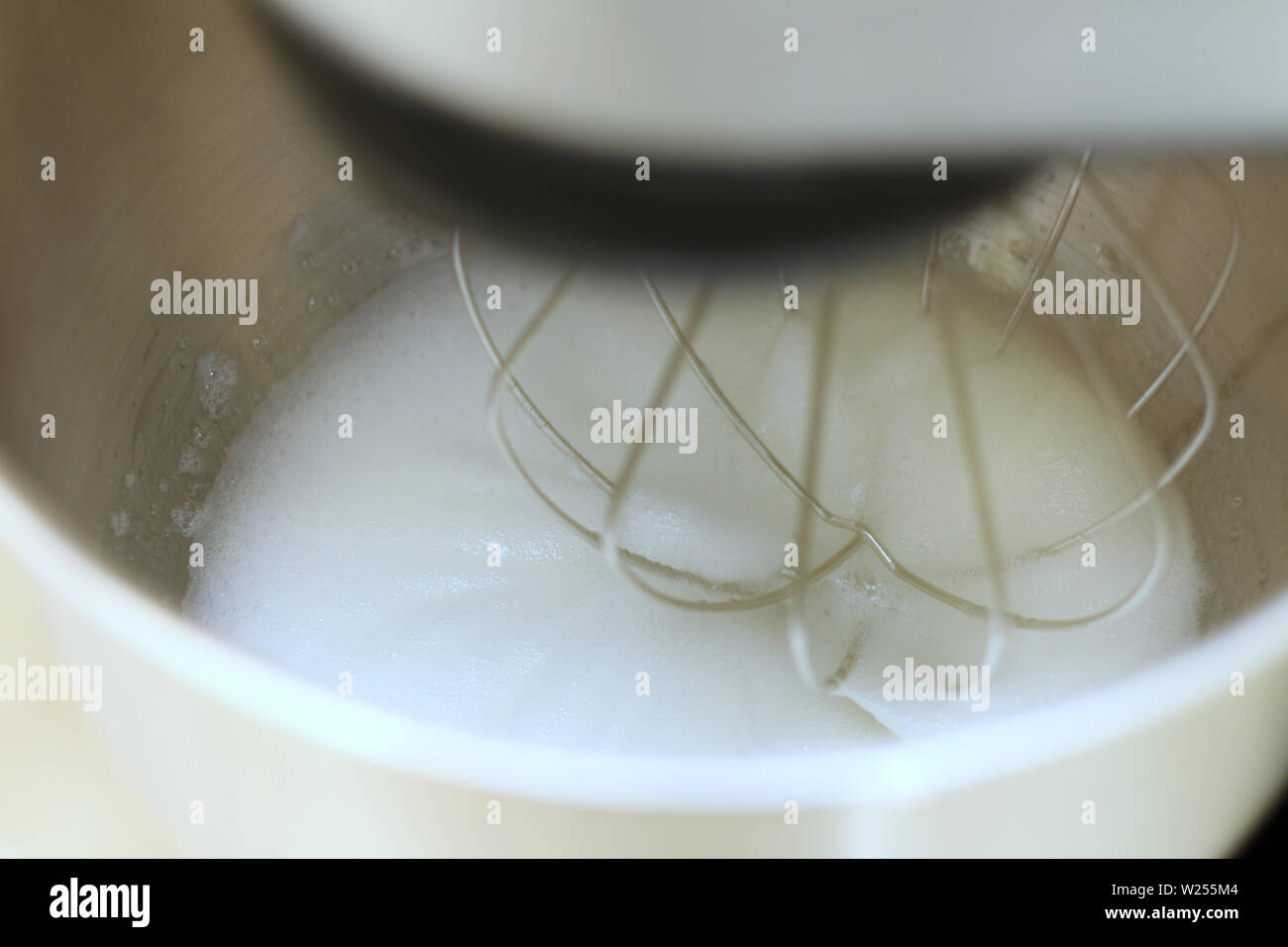 Whipping egg whites in professional kitchen mixer in a restaurant