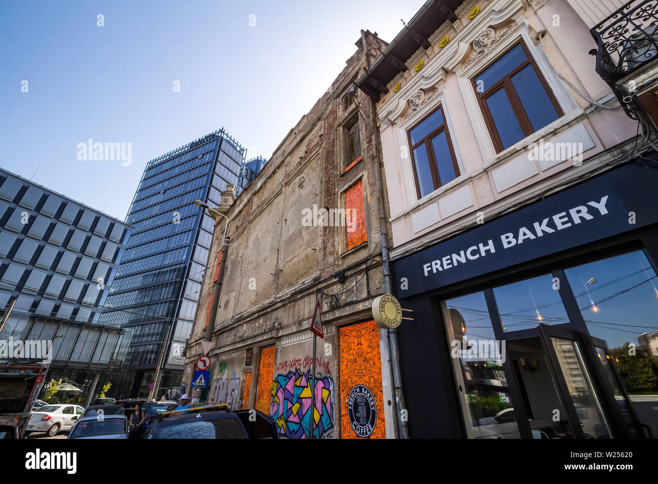 Bucharest, Romania - July 07, 2019: A modern high-rise building, called The Mark Tower, in contrast to some old buildings located on a street in Bucha Stock Photo