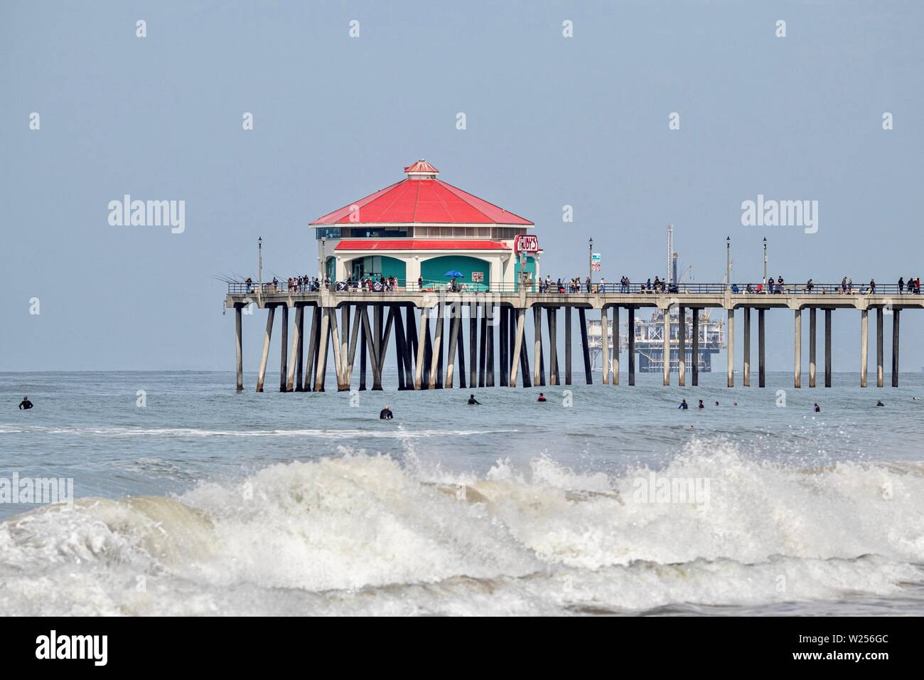 Huntington Beach Pier with surfers in the water Stock Photo