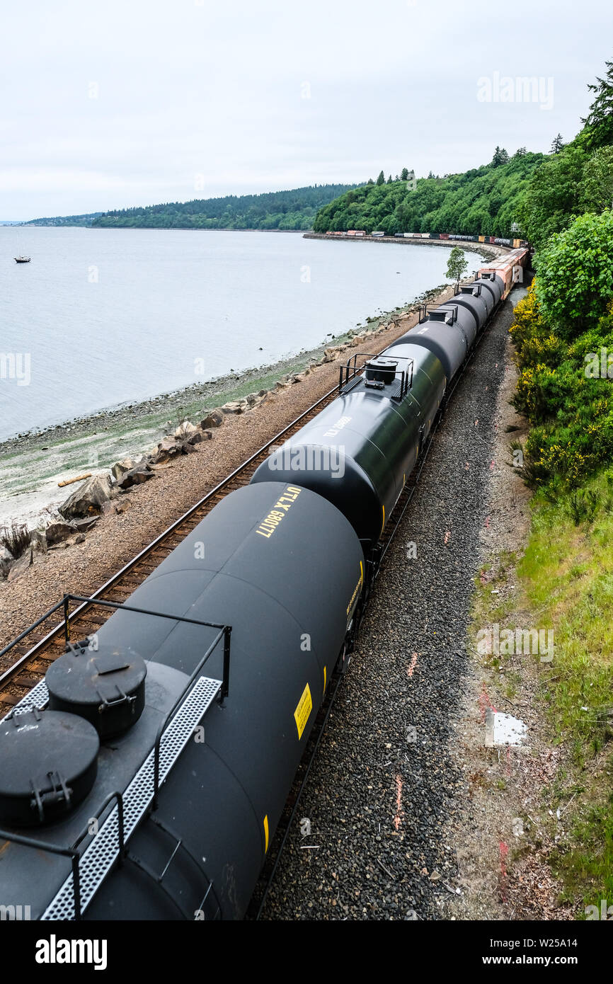 Long Northern Burlington freight train move along Puget Sound coastline Stock Photo