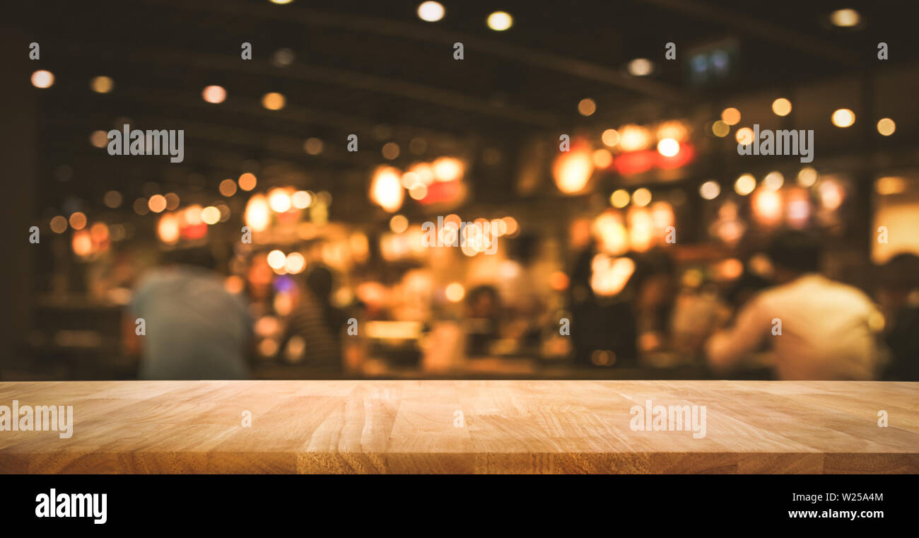 Wood table top (Bar) with blur light bokeh in dark night cafe