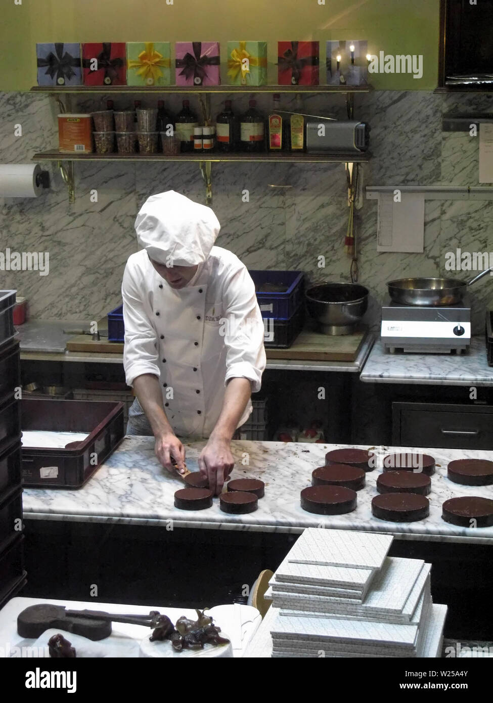 Young Chef preparing Sacher Torte Cakes in the kitchen of Cafe Demel, Vienna, Austria Stock Photo