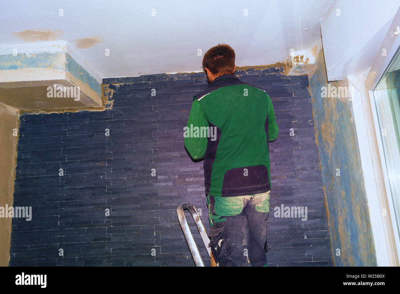 Ceramic tiles. Tilers of ceramic tiles glued to the wall Stock Photo