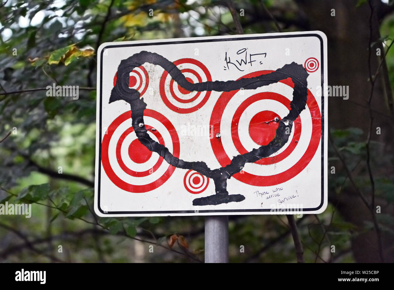 Sign with outlines of a chicken with multiple red target marks on it as part of art exhibition in forest Stock Photo