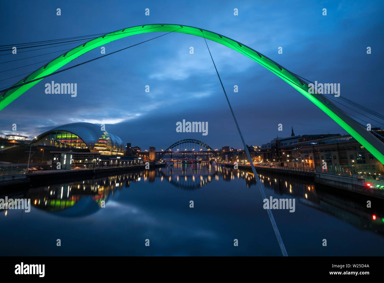 Gateshead quayside at night through the arch of the Millennium Bridge, looking toward the Sage and the Tyne Bridge, Tyne & Wear, England Stock Photo