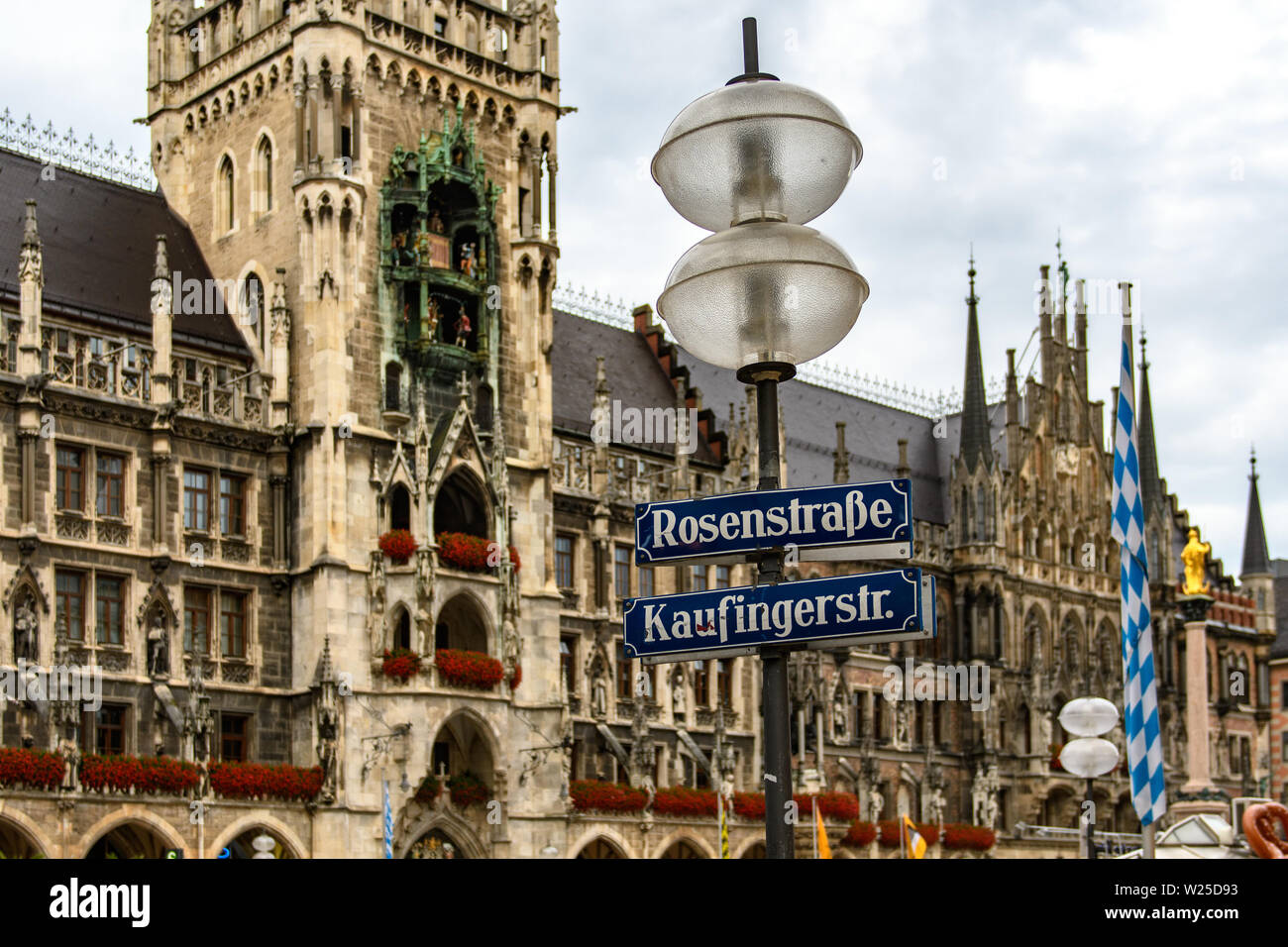 MUNICH, GERMANY - JUL 2017: Street lamp with street signs on the background of the old town hall of Gothic architecture. Autumn rain. Stock Photo
