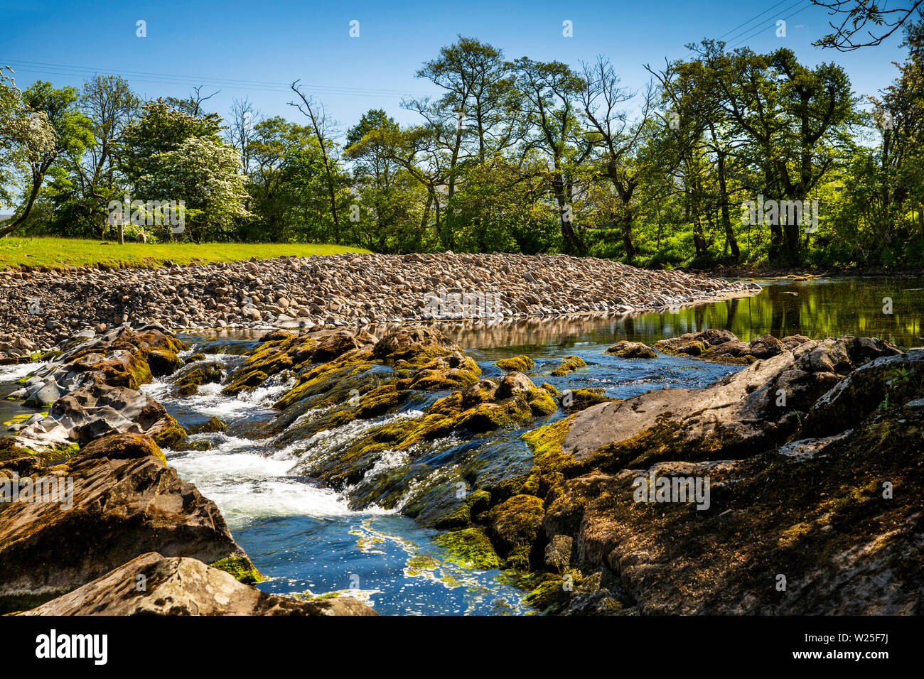 UK, Cumbria, Sedbergh, Millthrop. River Rawthey flowing over bedrock on bend with rocky deposition Stock Photo