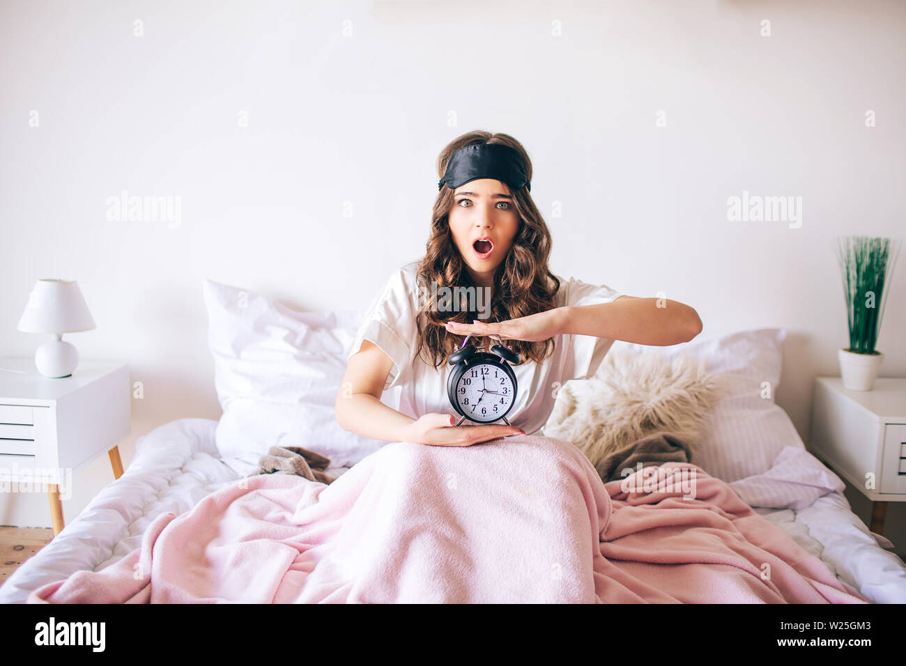 Dark haired beautiful young brunette wake up in her bed. Confused