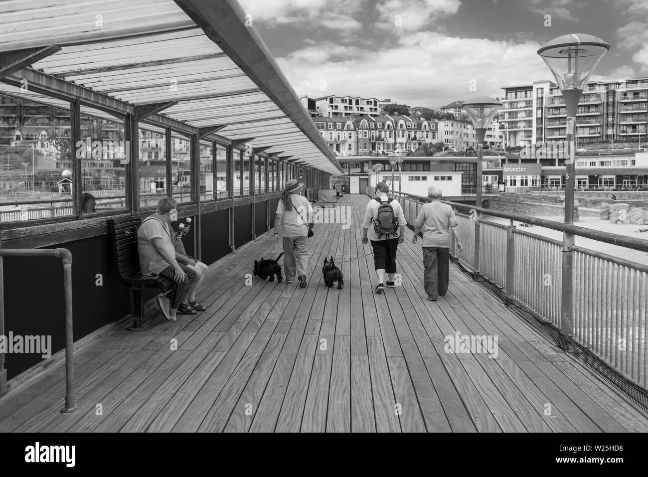 Black and white English seaside scene with people on the pier at Boscombe, Dorset, England, UK Stock Photo