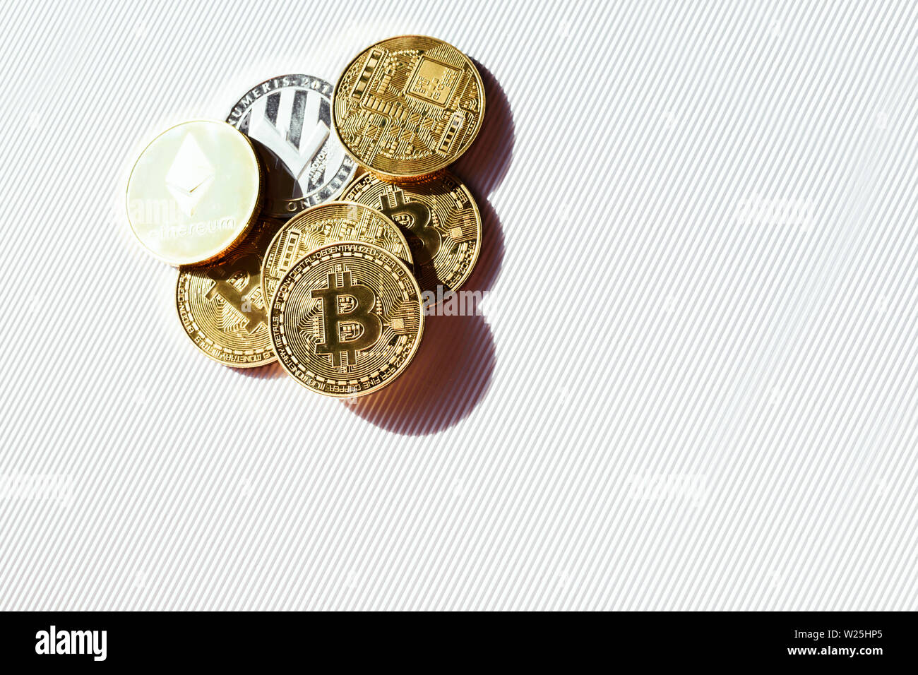 Top view of shiny coins with a bitcoin, lisk and ethereum symbols. Concept of finance in internet. Virtual crypto currency. Stock Photo