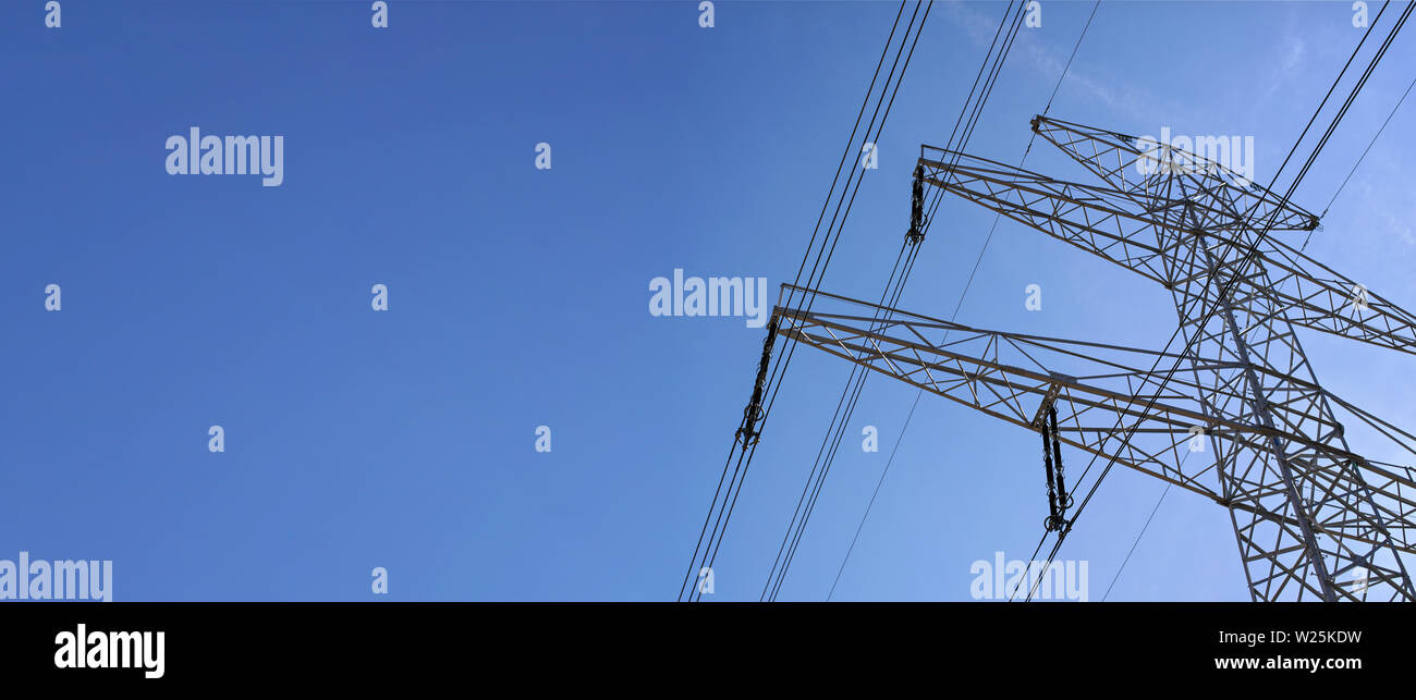 Looking up steel power pylon construction with high voltage cables ...